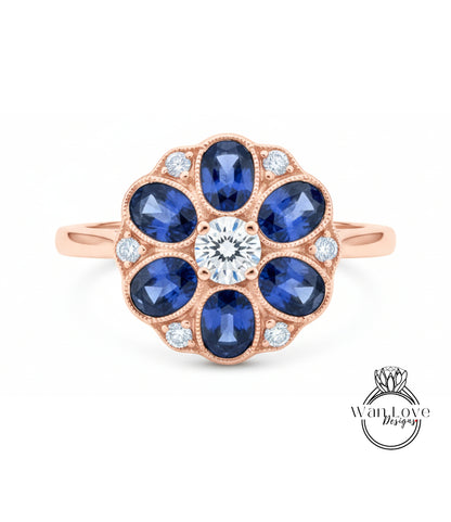 a beautiful rose gold ring with a large central diamond surrounded by smaller diamonds, set in a blue sapphire flower design.