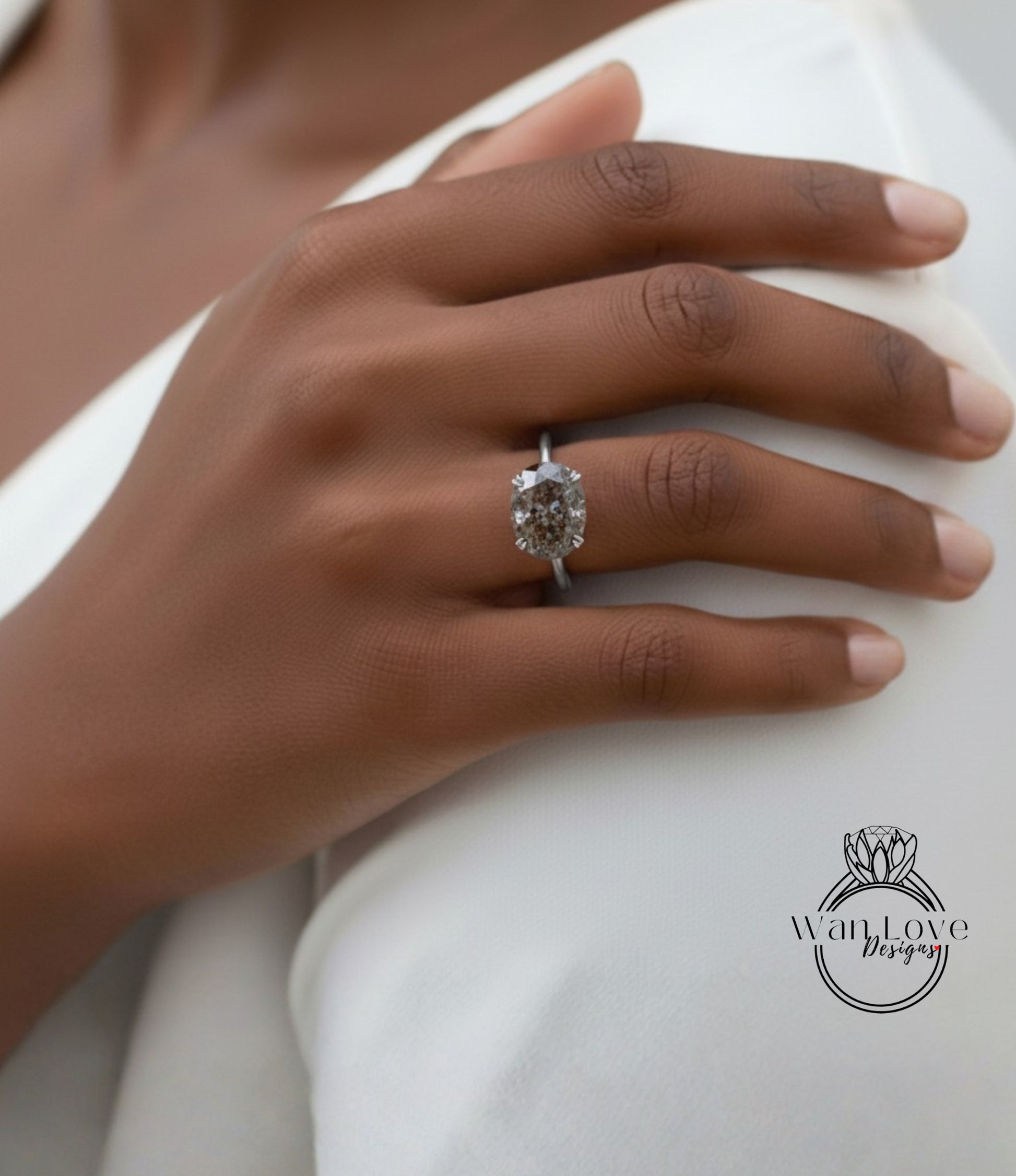 A close-up of a person's hand wearing a diamond engagement ring.