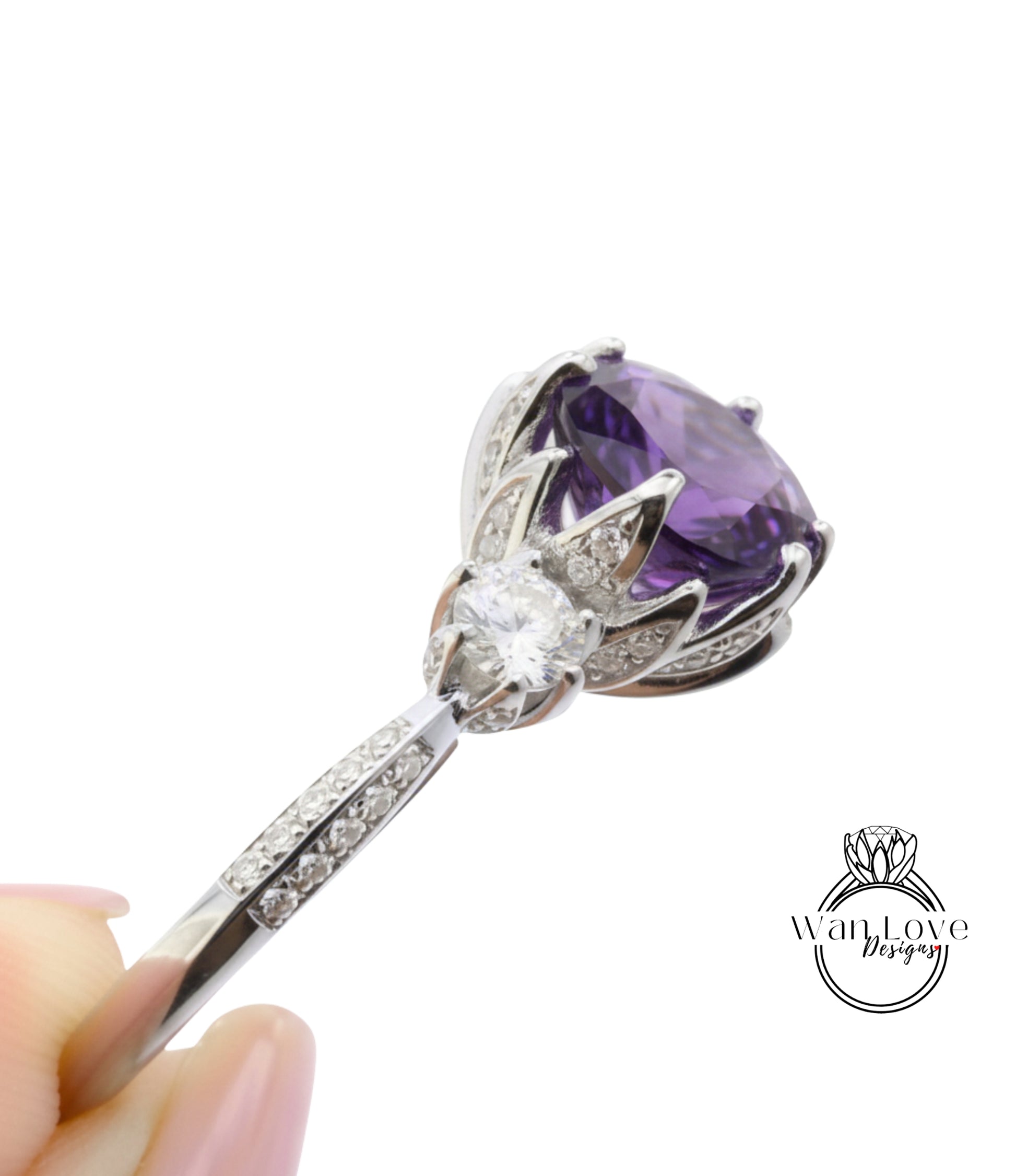 A close-up view of a silver ring with a large purple gemstone, possibly an amethyst, and a smaller clear gemstone.