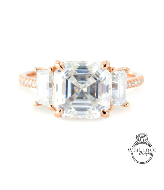 A large, clear gemstone ring with three smaller diamonds set in the center.