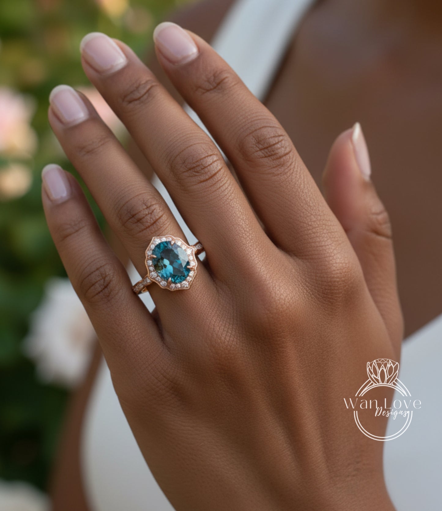 A close-up of a person's hand wearing a gold ring with a blue gemstone, likely an oval-shaped blue gemstone.