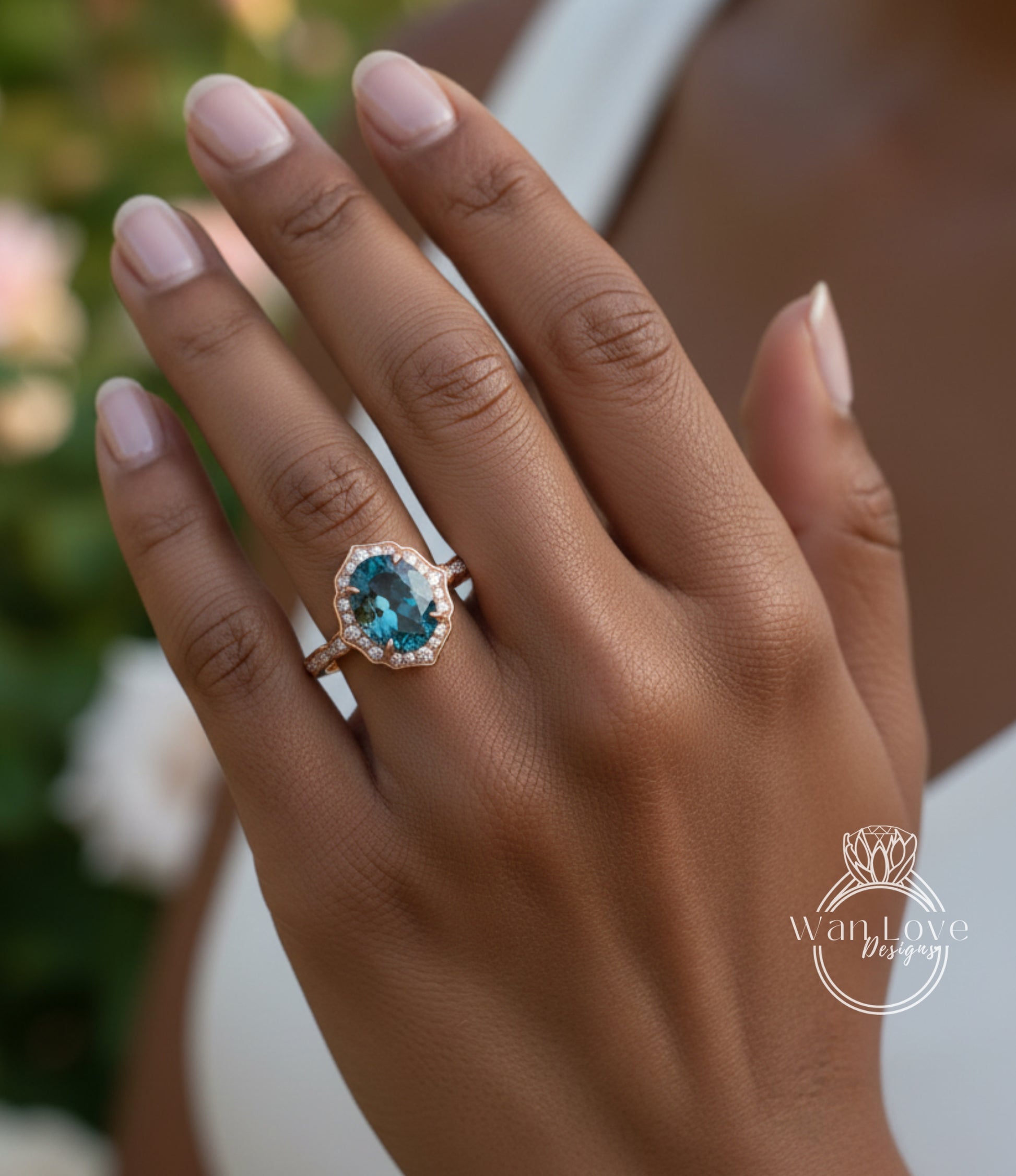 A close-up of a person's hand wearing a gold ring with a blue gemstone, likely an oval-shaped blue gemstone.