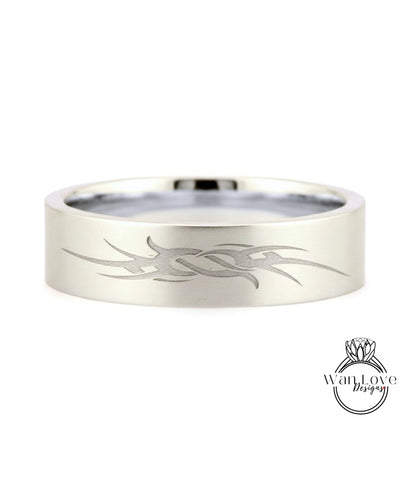 A silver-colored ring with a unique engraved design on its surface.