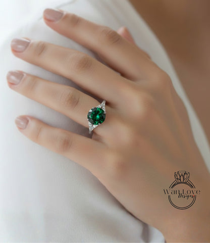 A close-up of a person's hand wearing a ring with a large, green gemstone.