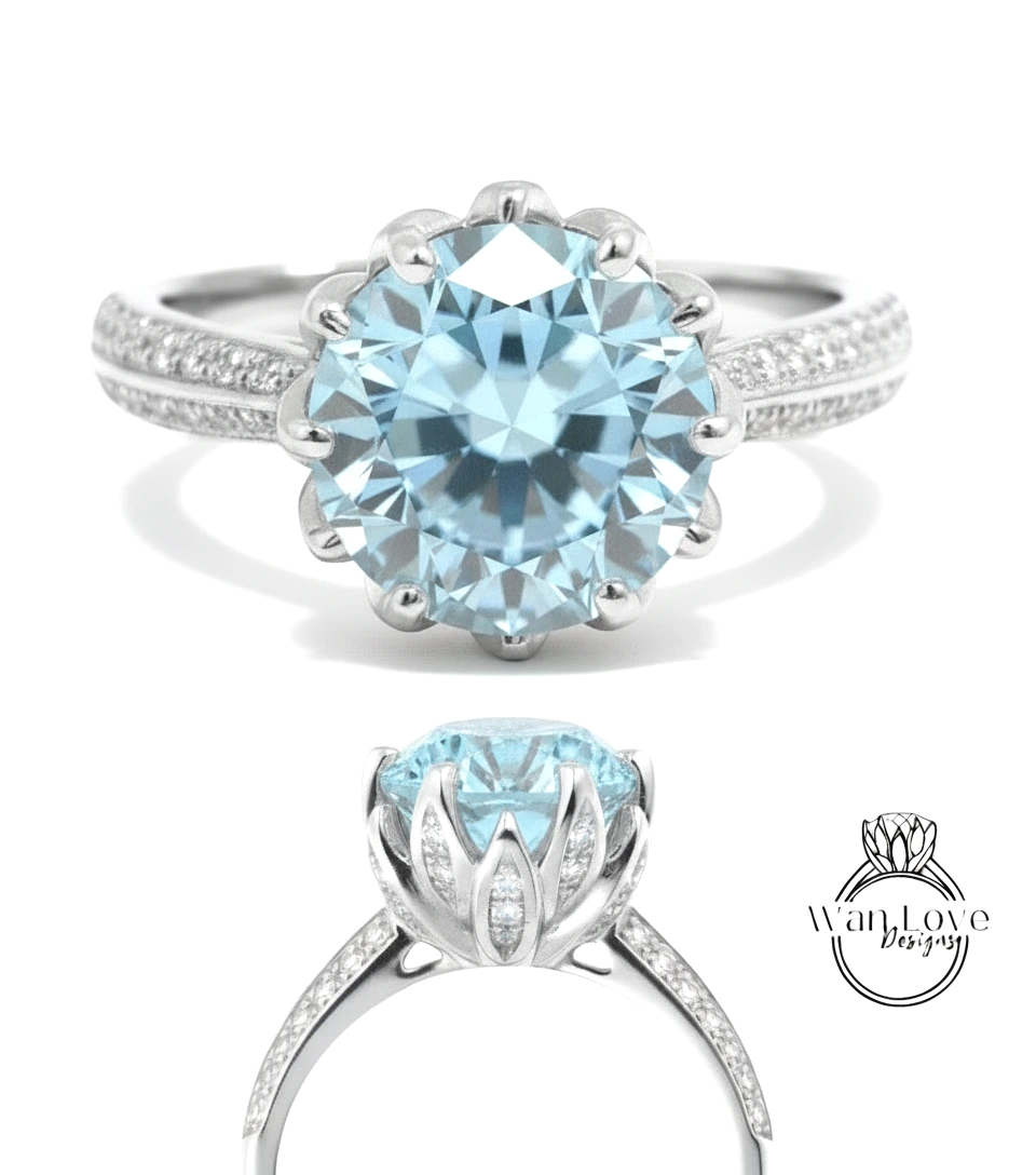 A stunning light blue diamond engagement ring with a large central diamond surrounded by smaller diamonds on either side, set in a silver band.
