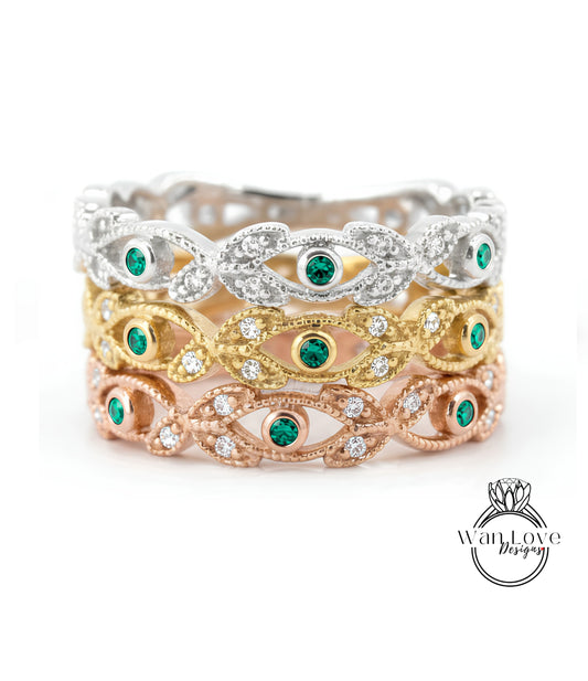 A ring with multiple layers of rings, each with a green gemstone in the center. The rings are arranged in a decorative manner, with the topmost ring being silver and the bottommost ring being gold.