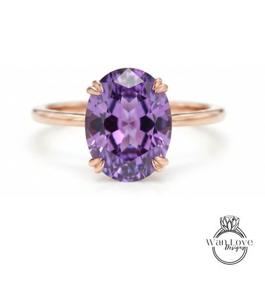 a ring with a large oval-shaped purple gemstone, which appears to be a diamond.
