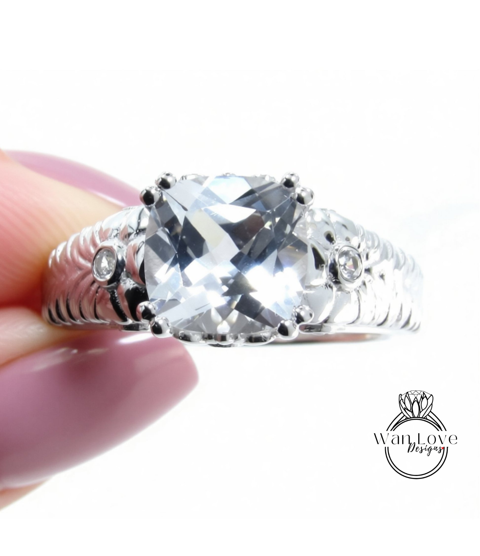 A close-up image of a person's hand holding a silver ring with a large, clear gemstone.