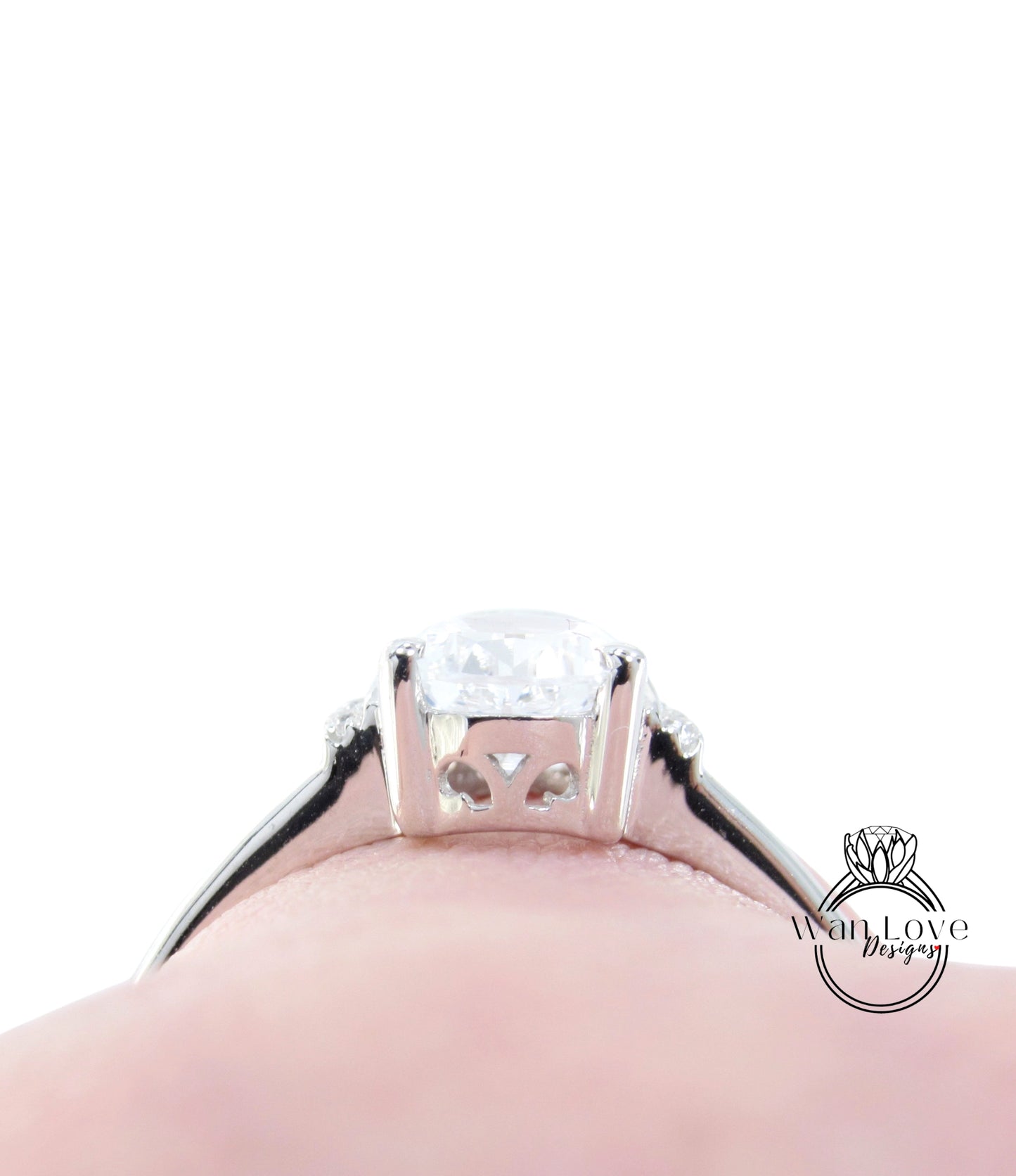 A close-up view of a diamond engagement ring on a person's finger, showcasing the intricate details and sparkle of the diamond.