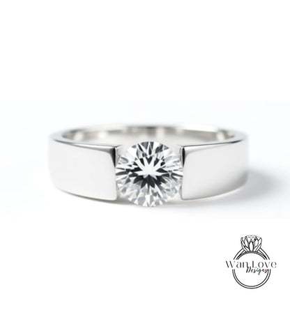A close-up view of a silver ring with a large, clear diamond set in the center.