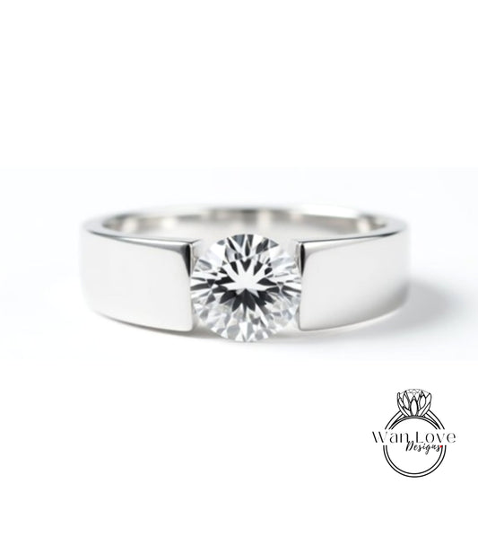 A close-up view of a silver ring with a large, clear diamond set in the center.