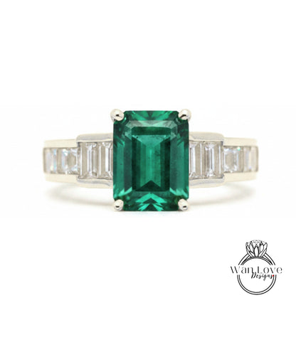 A ring featuring a large, vibrant green gemstone surrounded by smaller diamonds set in a silver band.