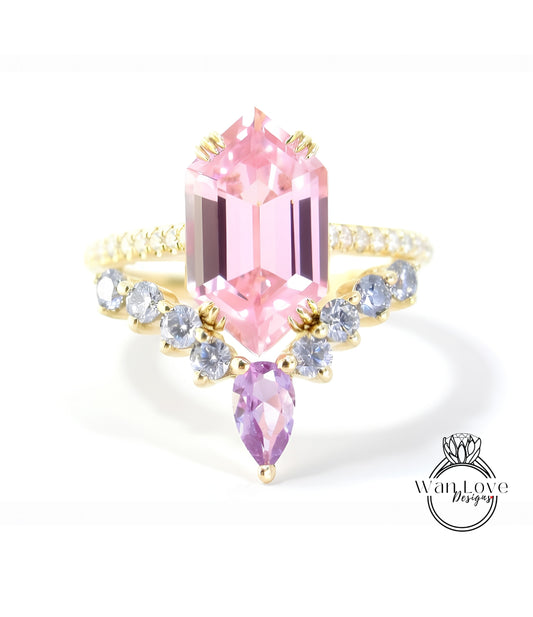 A pink gemstone ring with a gold band and a row of smaller diamonds on either side.