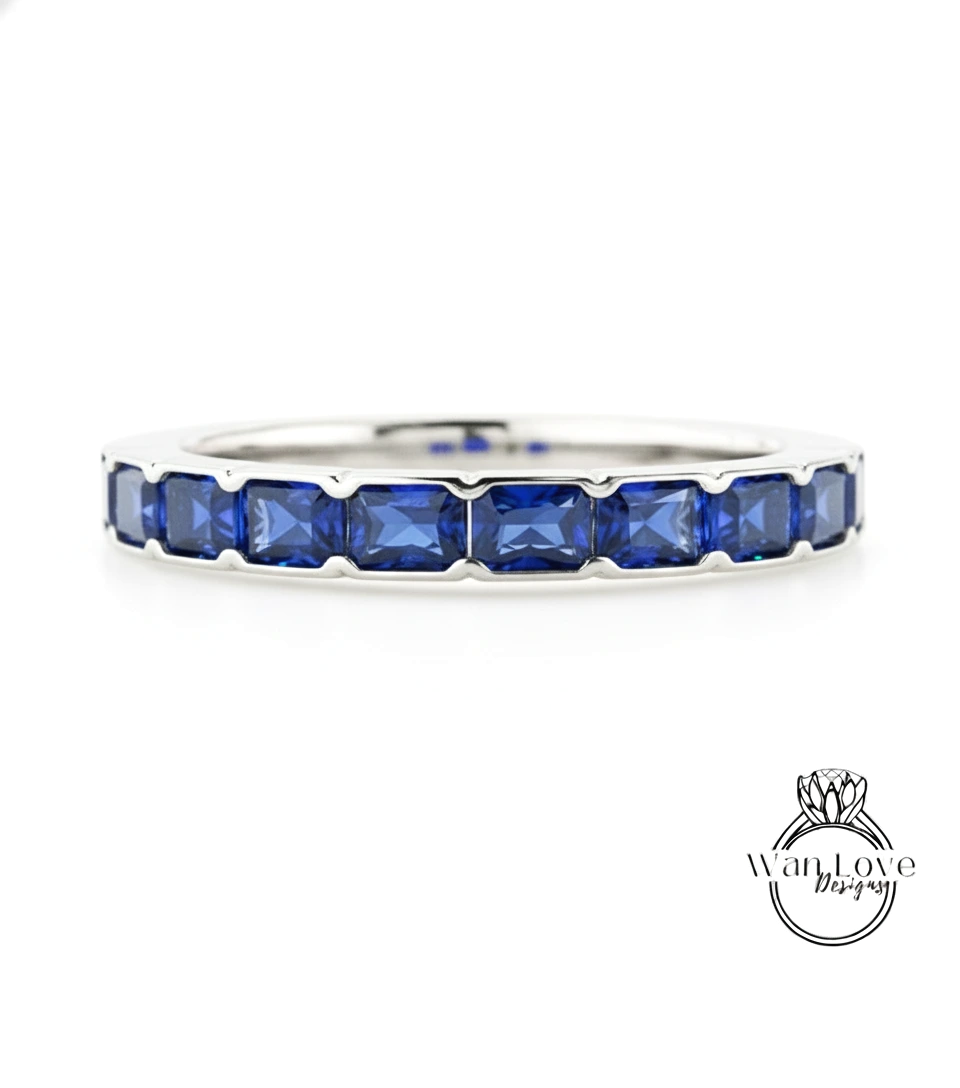 A silver band ring with a row of blue sapphire gemstones set in it.