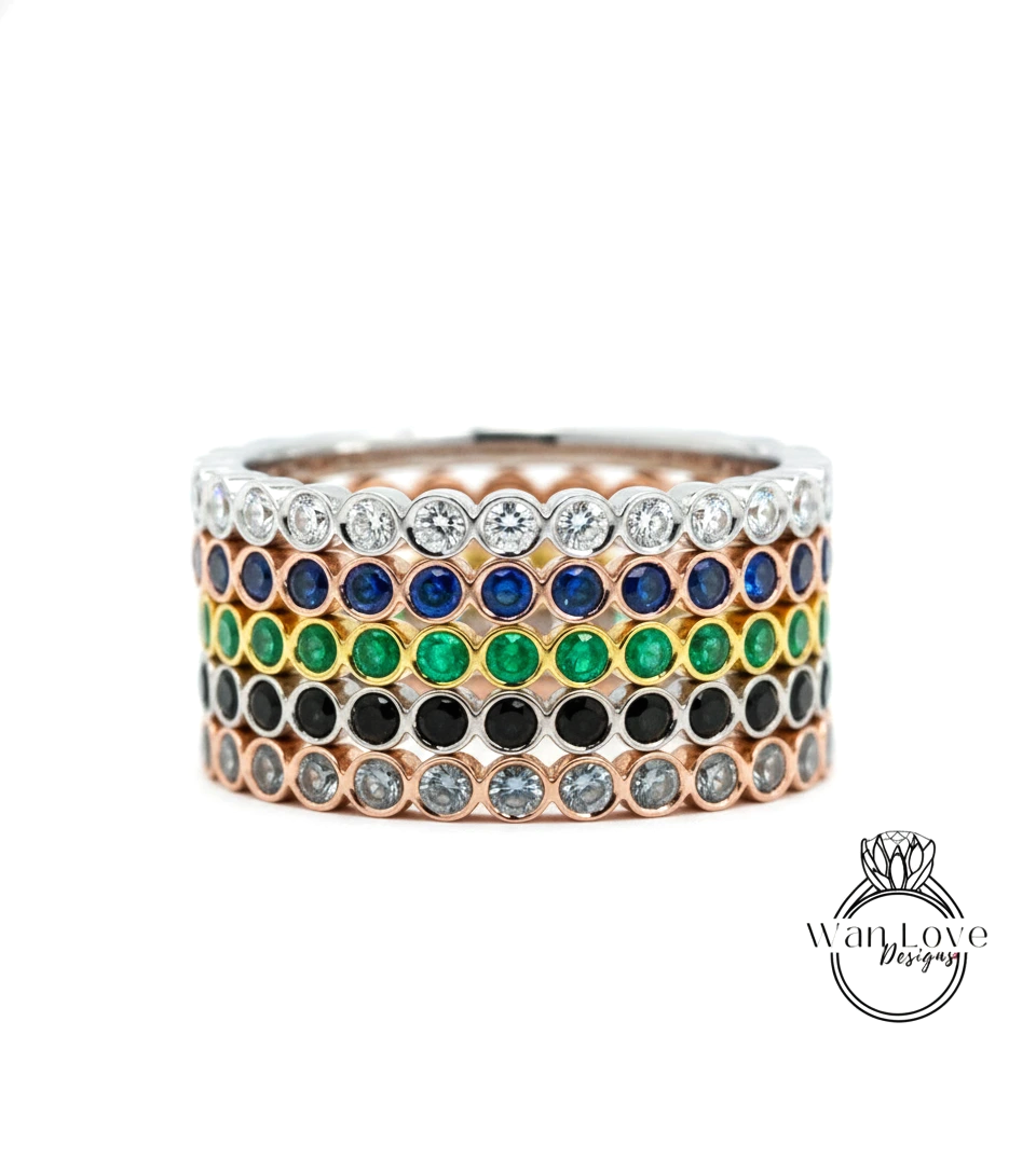 A ring with a row of colorful gemstones, including diamonds and various colored stones, set in a silver band.