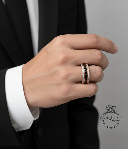 A close-up of a person's hand wearing a gold ring with a black gemstone band.