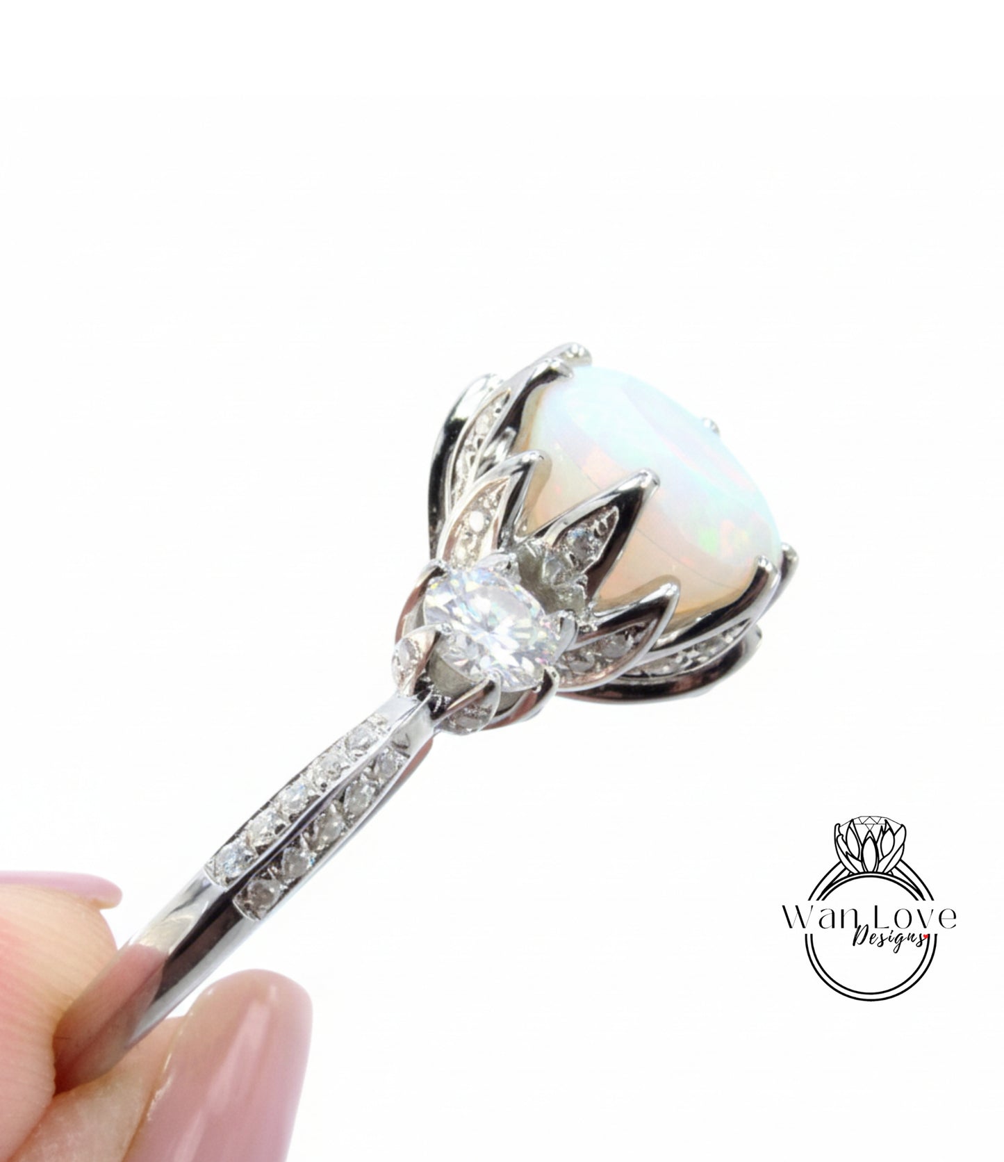 A close-up view of a diamond engagement ring with a large opal stone set in a silver band.