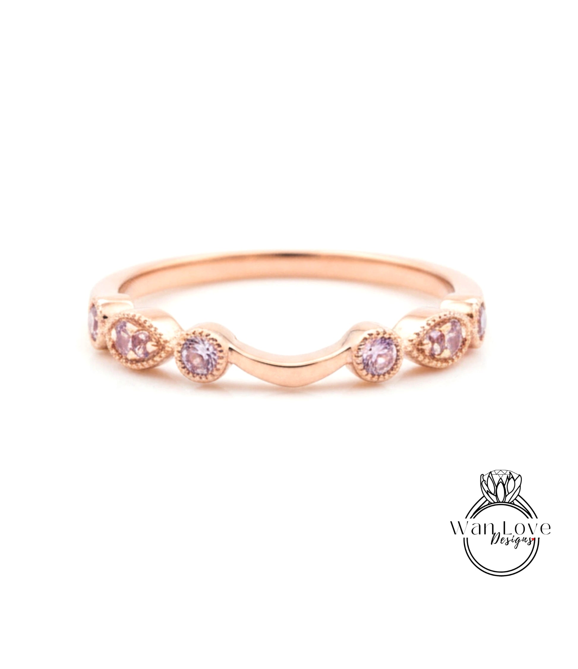 A rose gold ring with a curved band and small pink gemstones.