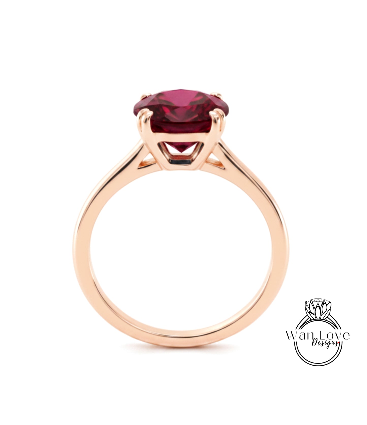 A gold ring with a large, deep red gemstone set in the center.