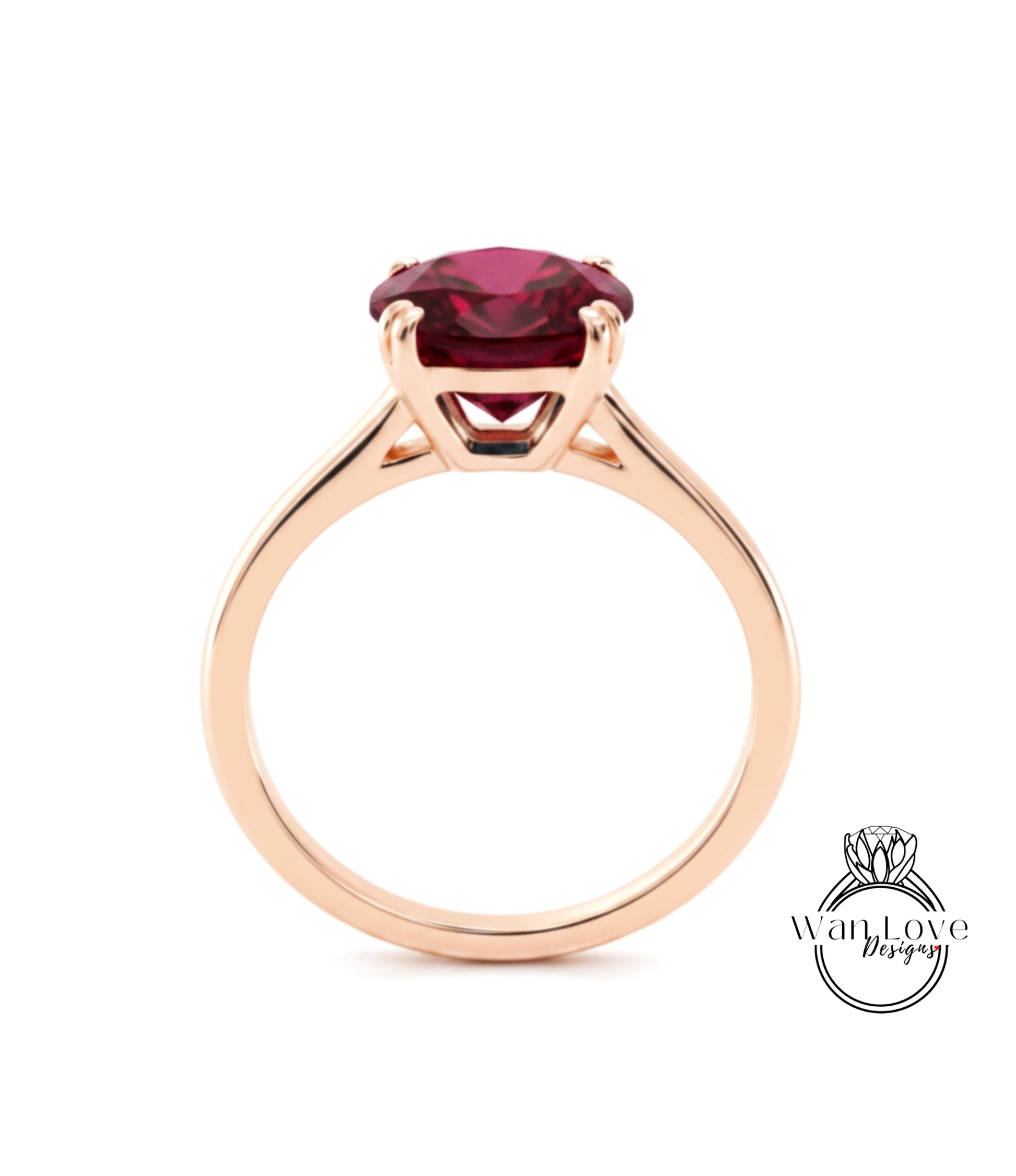 A gold ring with a large, deep red gemstone set in the center.
