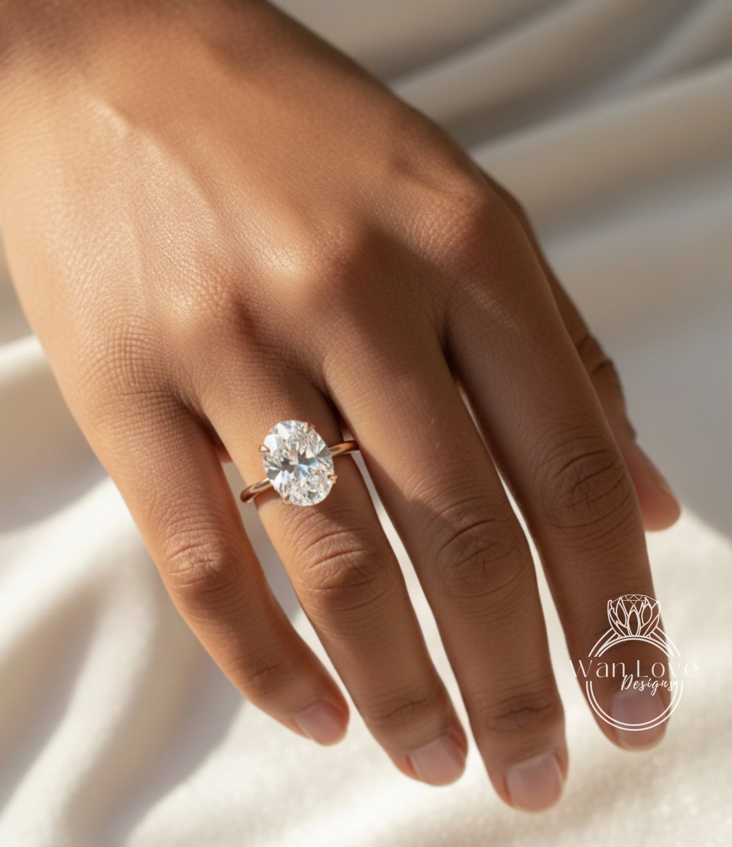 A close-up of a person's hand wearing a large oval-shaped diamond engagement ring.