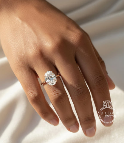 A close-up of a person's hand wearing a large oval-shaped diamond engagement ring.