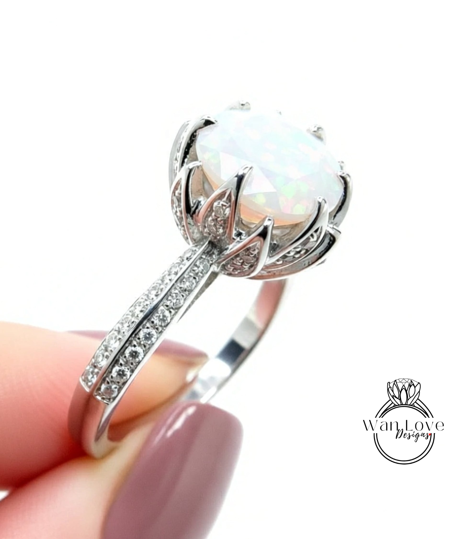 A close-up of a silver ring with a large, round opal stone set in a decorative metal band.