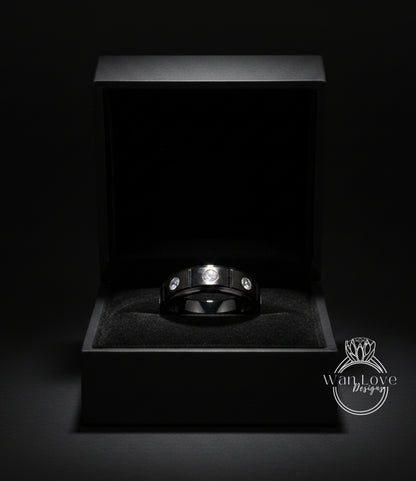 A black jewelry box containing a silver ring with three diamonds.