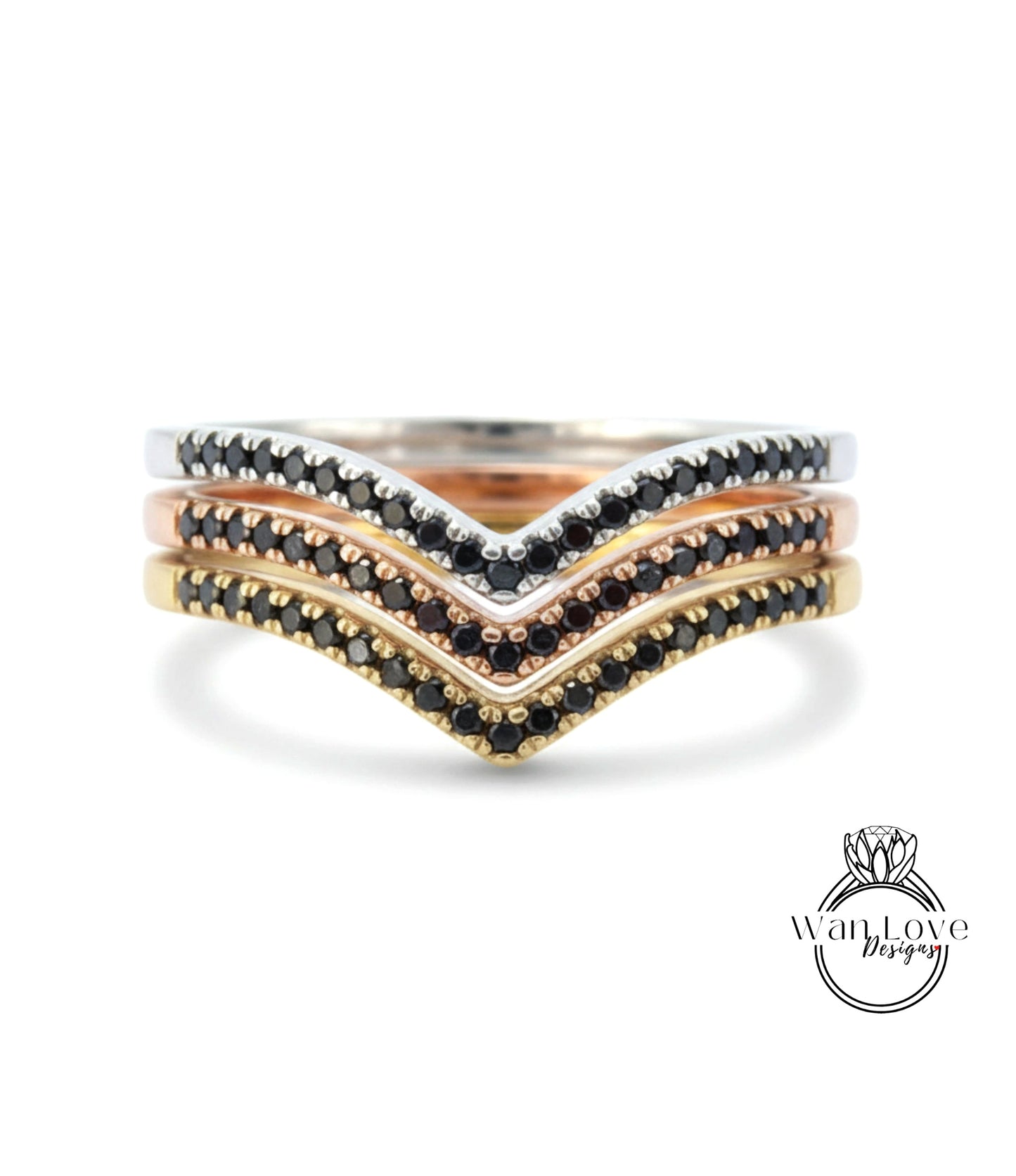 A ring with three layers of rings, each with a black diamond accent. The topmost ring is silver, the middle ring is gold, and the bottom ring is rose gold. The rings are adorned with black diamonds.