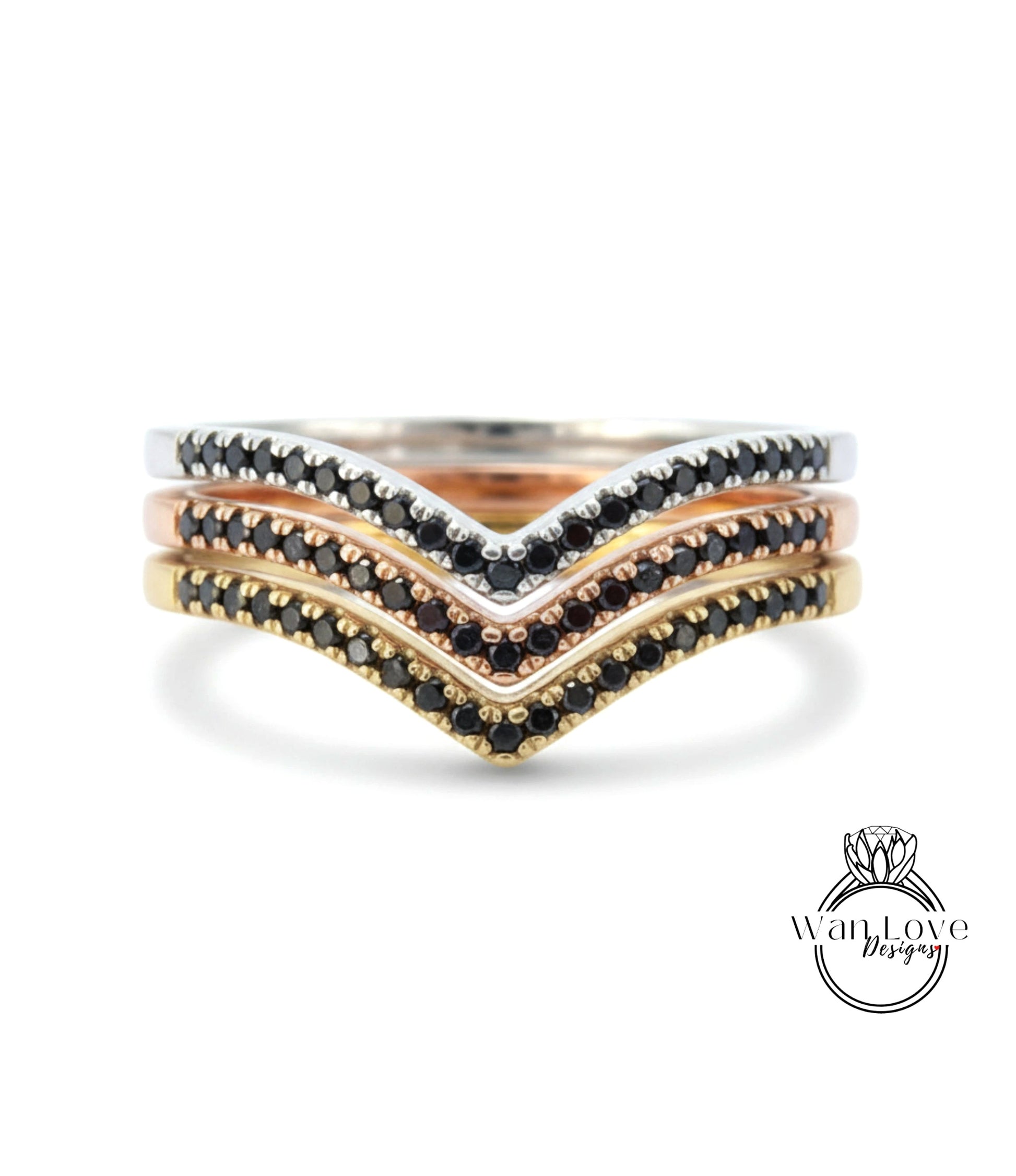 A ring with three layers of rings, each with a black diamond accent. The topmost ring is silver, the middle ring is gold, and the bottom ring is rose gold. The rings are adorned with black diamonds.