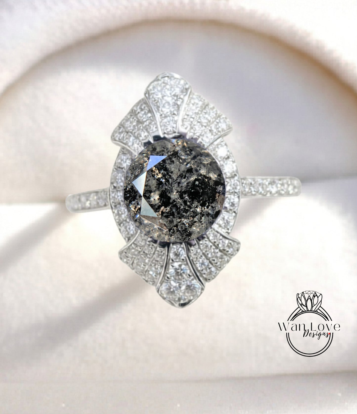 A close-up image of a diamond engagement ring with a large, dark diamond at the center, surrounded by smaller diamonds and set in a silver band.