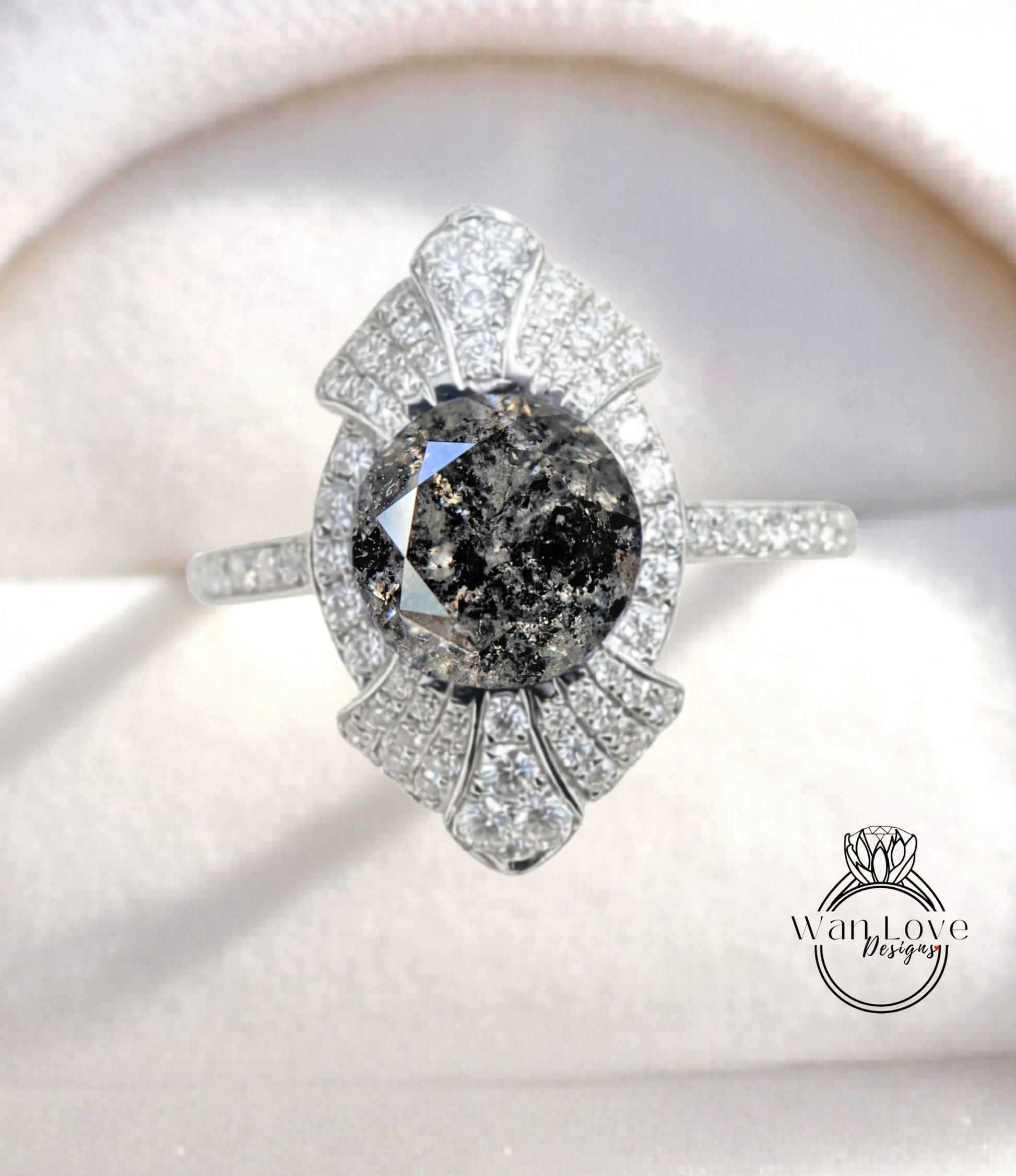A close-up image of a diamond engagement ring with a large, dark diamond at the center, surrounded by smaller diamonds and set in a silver band.