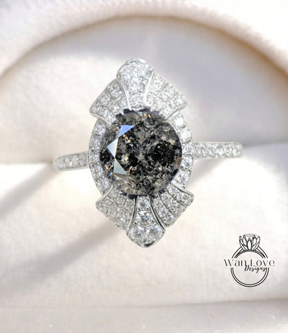 A close-up image of a diamond engagement ring with a large, dark diamond at the center, surrounded by smaller diamonds and set in a silver band.