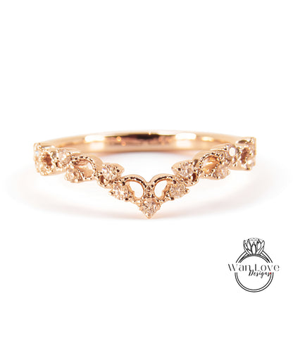 A gold ring with a decorative floral design and small diamonds.
