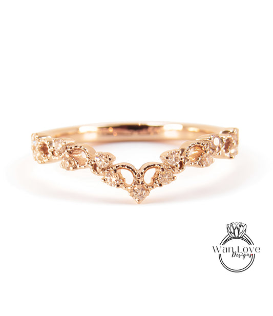 A gold ring with a decorative floral design and small diamonds.