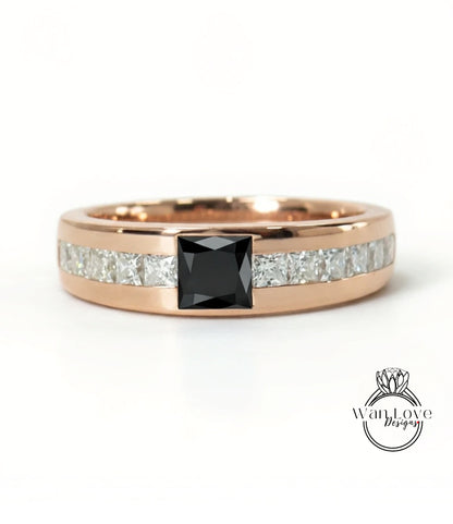 A rose gold ring with a large black gemstone in the center, surrounded by smaller diamonds.