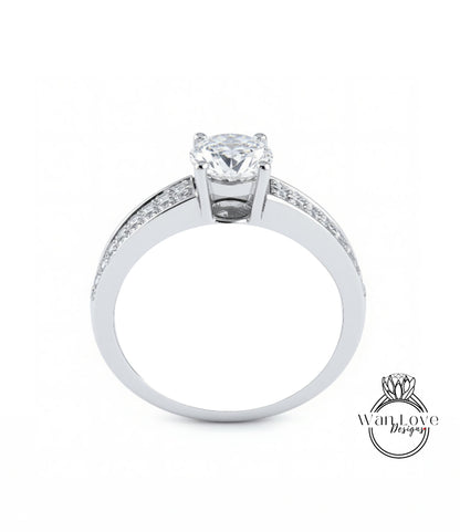 A silver engagement ring with a large central diamond and smaller diamonds along the band.