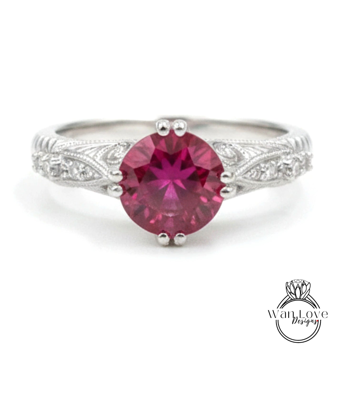 A close-up image of a silver ring with a large, deep red gemstone at the center.