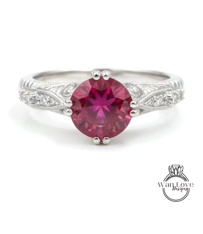 A close-up image of a silver ring with a large, deep red gemstone at the center.