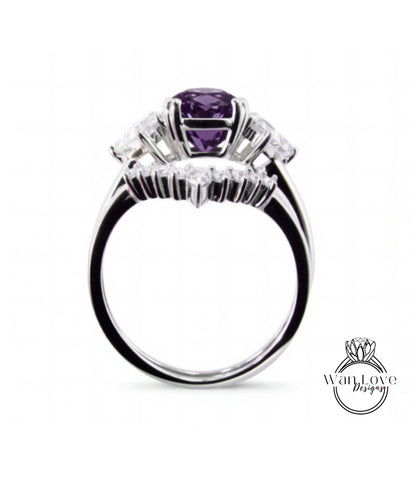 A silver ring with a large purple gemstone, surrounded by smaller diamonds, set in a halo of smaller diamonds.