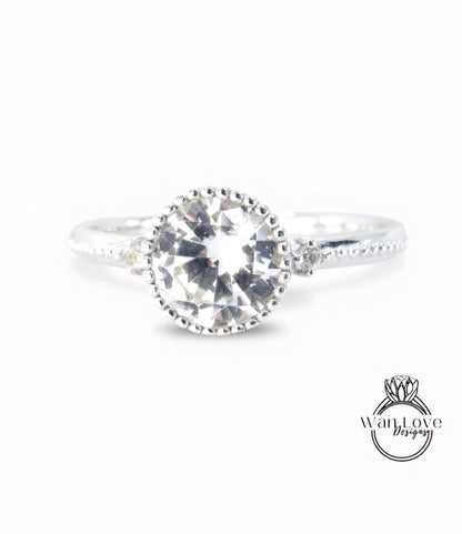 A close-up view of a silver ring with a large, clear gemstone set in the center.