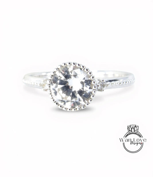 A close-up view of a silver ring with a large, clear gemstone set in the center.