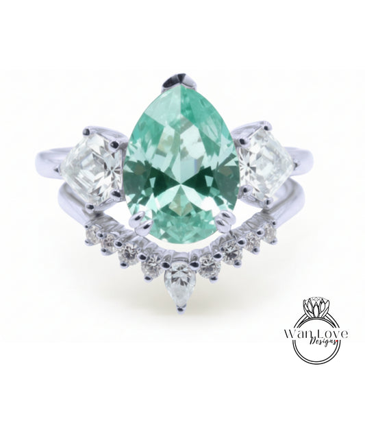 A silver ring with a large, green gemstone at the center, surrounded by smaller diamonds.