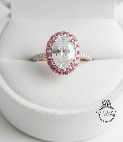 A close-up image of a diamond engagement ring with a large oval-shaped diamond surrounded by a halo of smaller diamonds and pink gemstones.