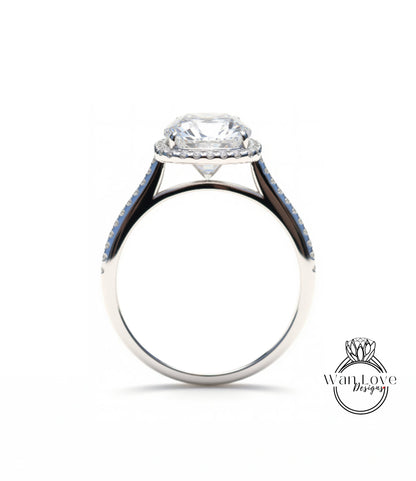 A silver engagement ring with a large central diamond and a halo of smaller diamonds around the center stone.