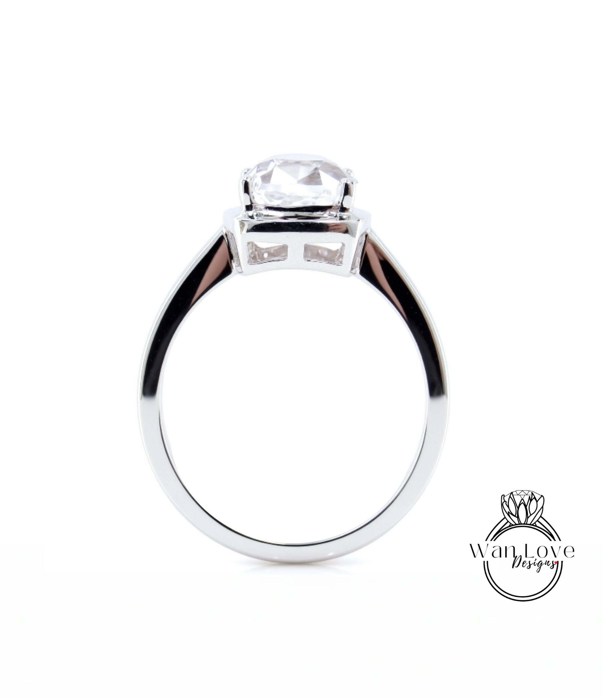A silver engagement ring with a large, clear gemstone set in the center.