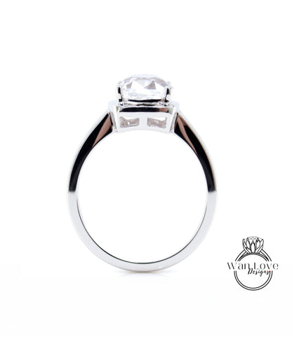 A silver engagement ring with a large, clear gemstone set in the center.