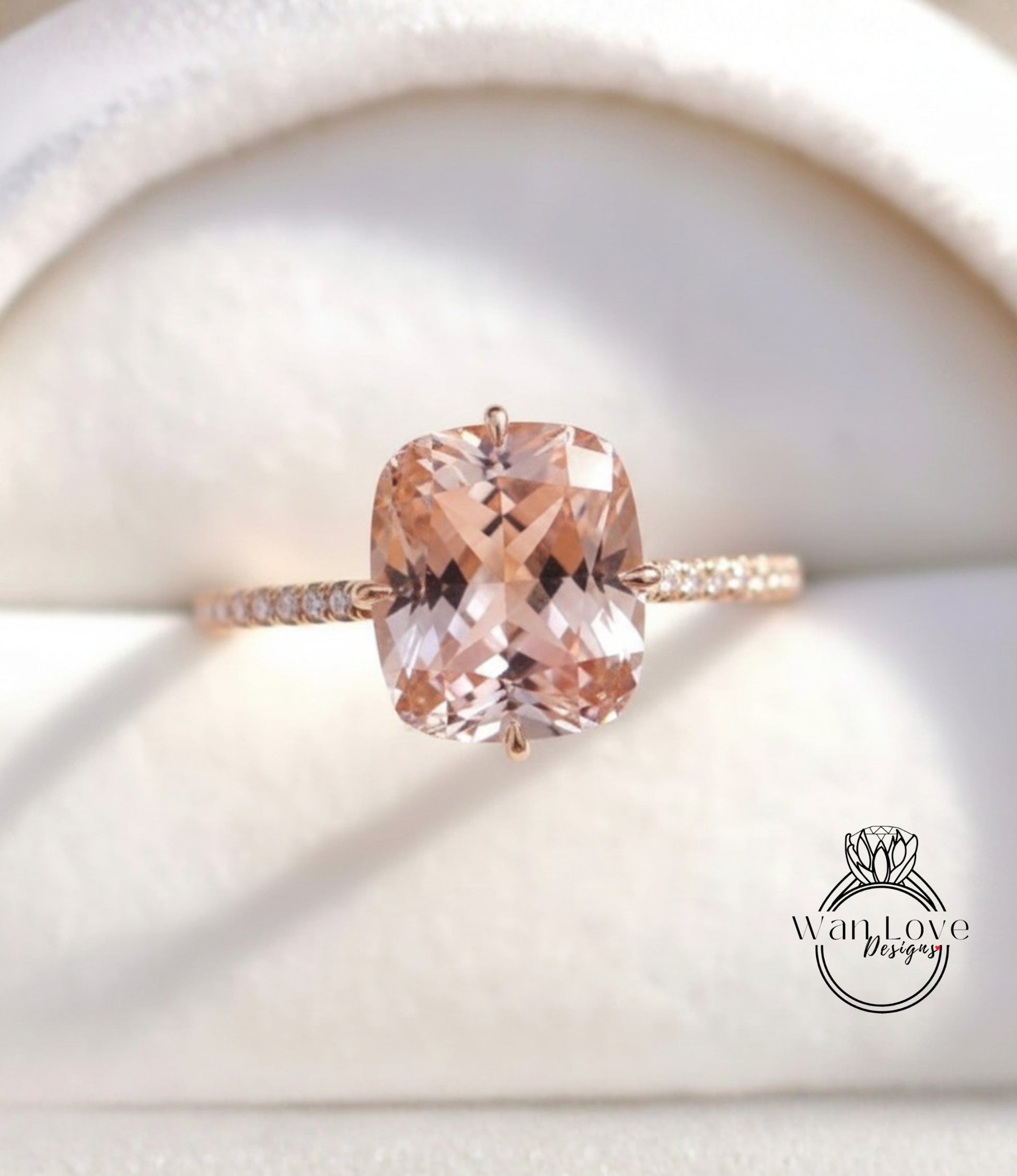 A close-up image of a gold ring with a large, light pink gemstone set in the center.