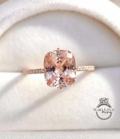 A close-up image of a gold ring with a large, light pink gemstone set in the center.