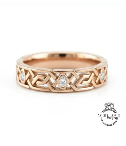 A gold ring with a Celtic knot design and a central oval-shaped diamond.